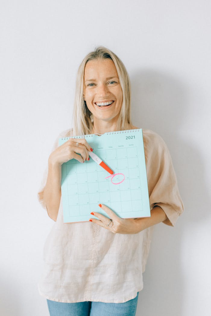 Crafting Captivating Headlines: Your awesome post title goes here Smiling woman holds calendar marking a date with joy and anticipation.